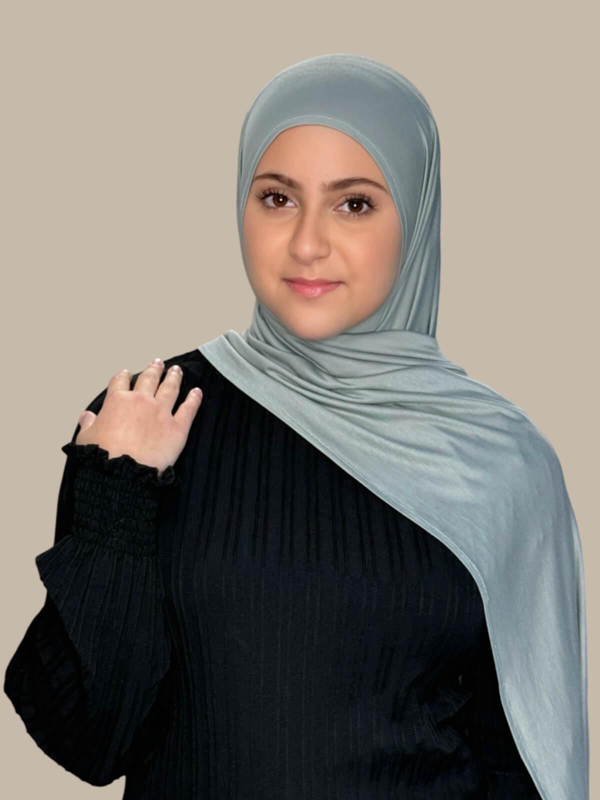 Stone Green Pre-Sewn Jersey Hijab in Modish Girl size, front view on model with hijab draped over shoulder showing smooth fit and soft stretch fabric.