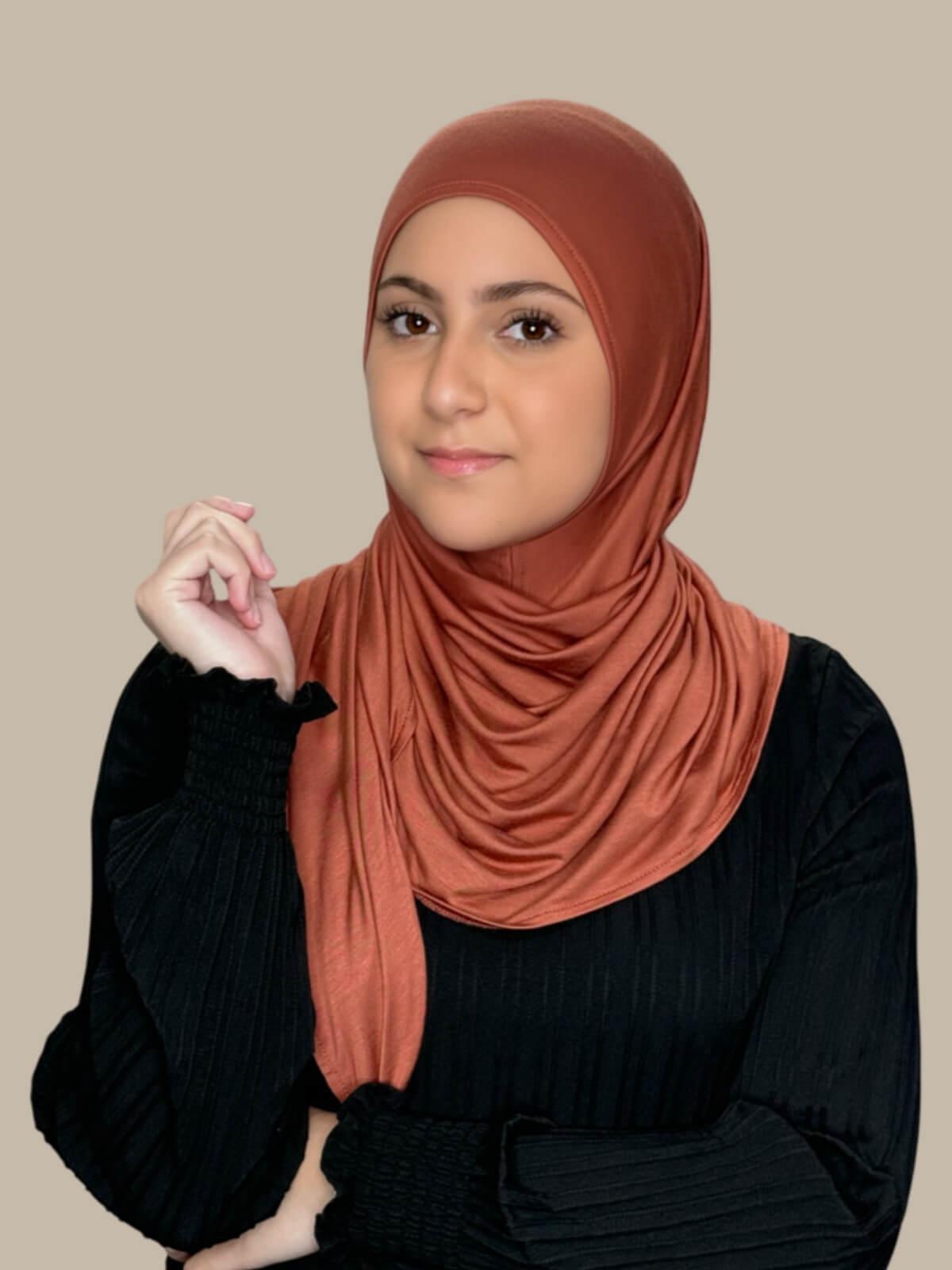 Brick Red Pre-Sewn Jersey Hijab in Modish Girl size, front view on model with hijab wrapped neatly around shoulders showing smooth fit and soft stretch fabric.