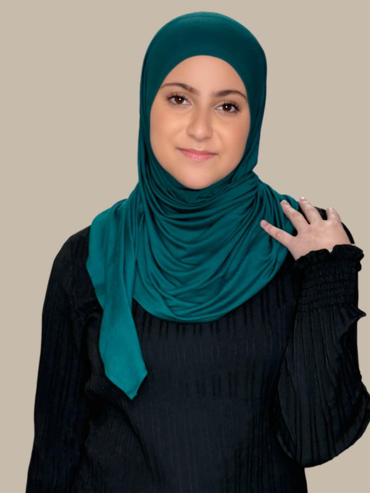 Pine Green Pre-Sewn Jersey Hijab in Modish Girl size, front view on model with hijab wrapped neatly around shoulders showing smooth fit and soft stretch fabric.