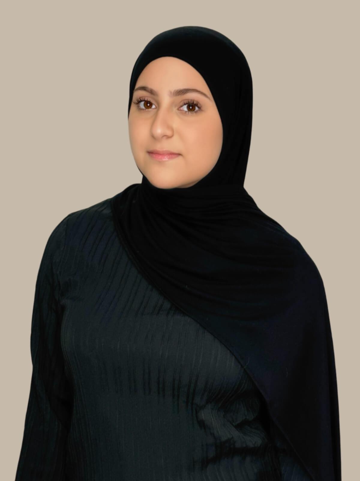 Black Pre-Sewn Jersey Hijab in Modish Girl size, side view on model with hijab draped over shoulder showing fabric length and fit.