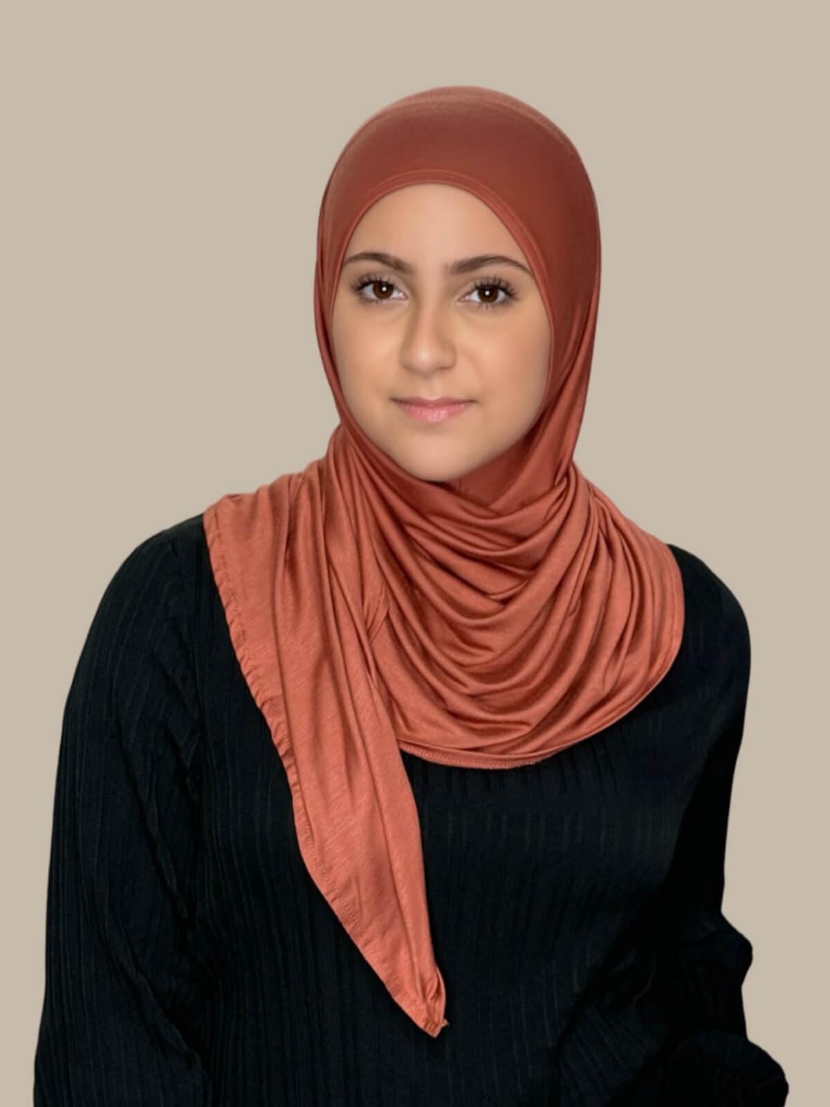 Brick Red Pre-Sewn Jersey Hijab in Modish Girl size, front view on model with hijab wrapped neatly around shoulders showing smooth fit and soft stretch fabric.